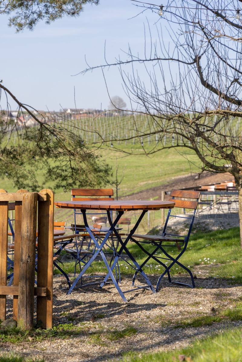 Gemütlicher Sitzplatz in der Besenbeiz des Lindenhofs in Buchberg mit Blick auf die Rebberge
